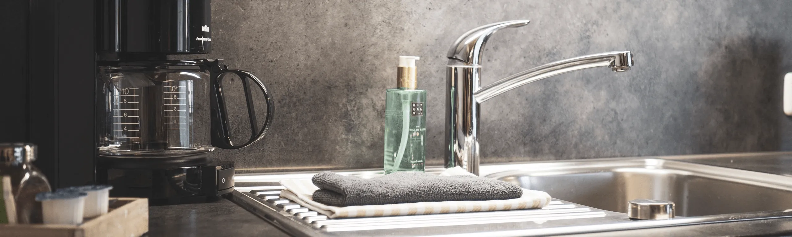 Moderne Küchenspüle mit Wasserhahn und Kaffeemaschine