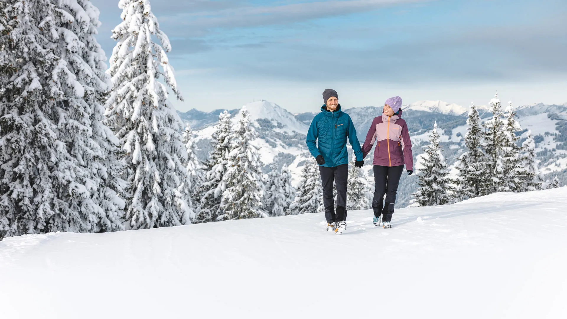 Zwei Frauen gehen in verschneiter Winterlandschaft spazieren