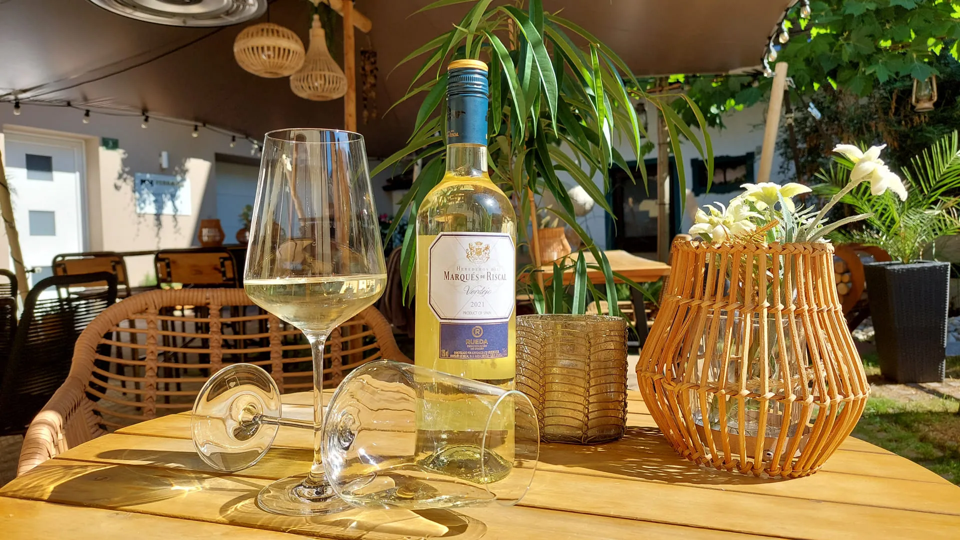 Weinflasche und Glas auf einem Tisch mit Pflanzen