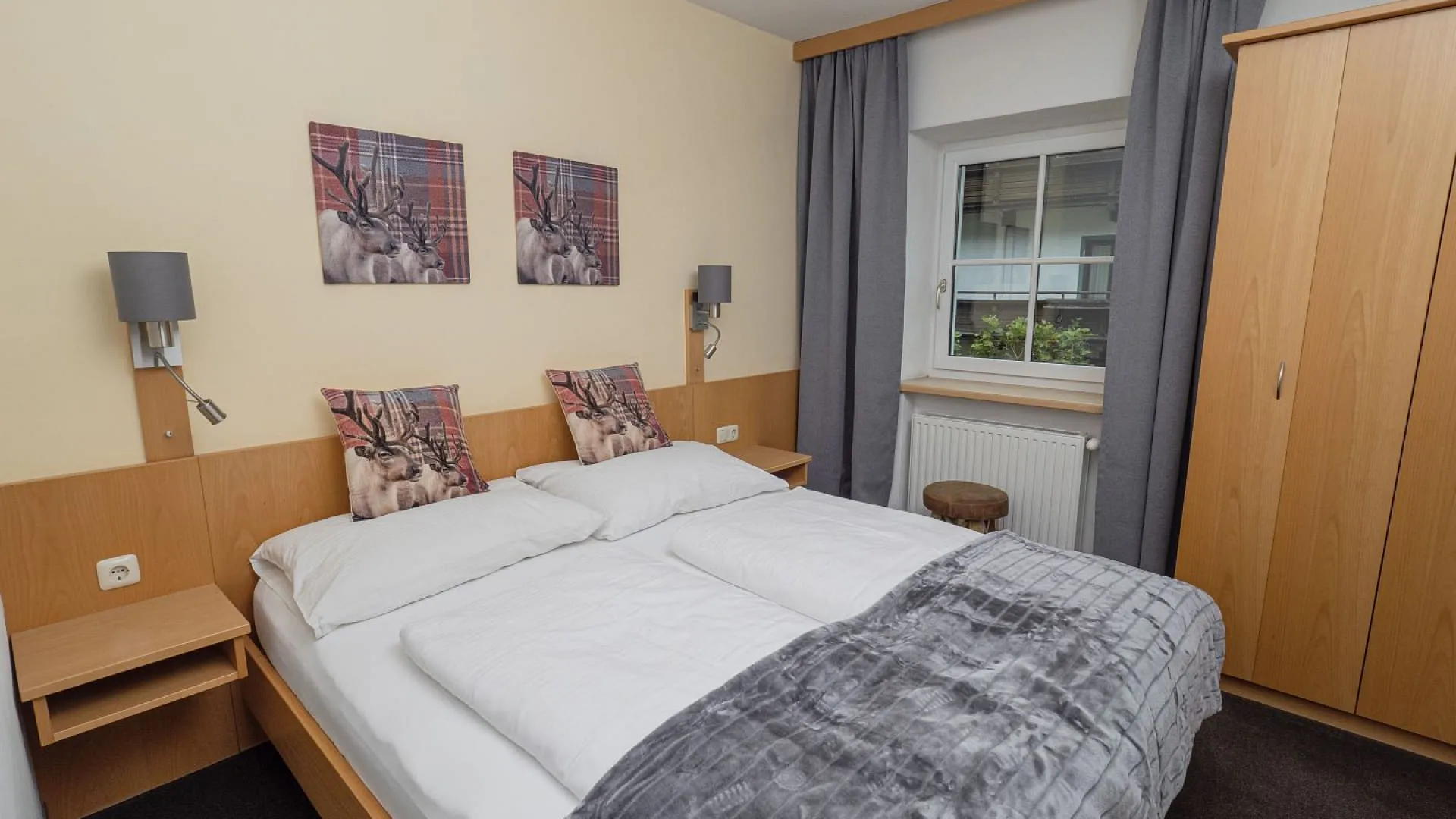 Helles Schlafzimmer mit Doppelbett und Holzschrank.