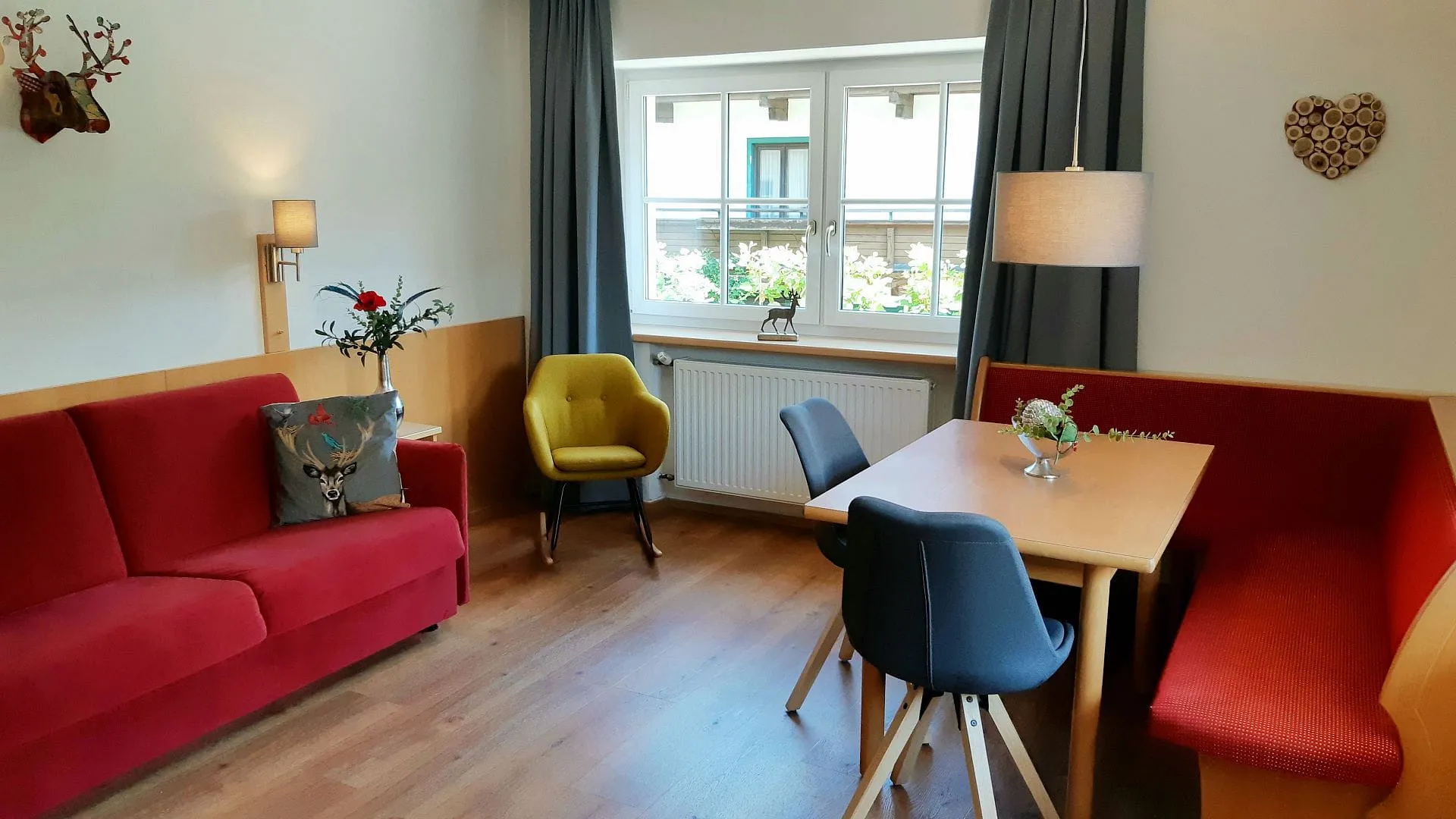 Gemütliches Wohnzimmer mit rotem Sofa und Tisch.