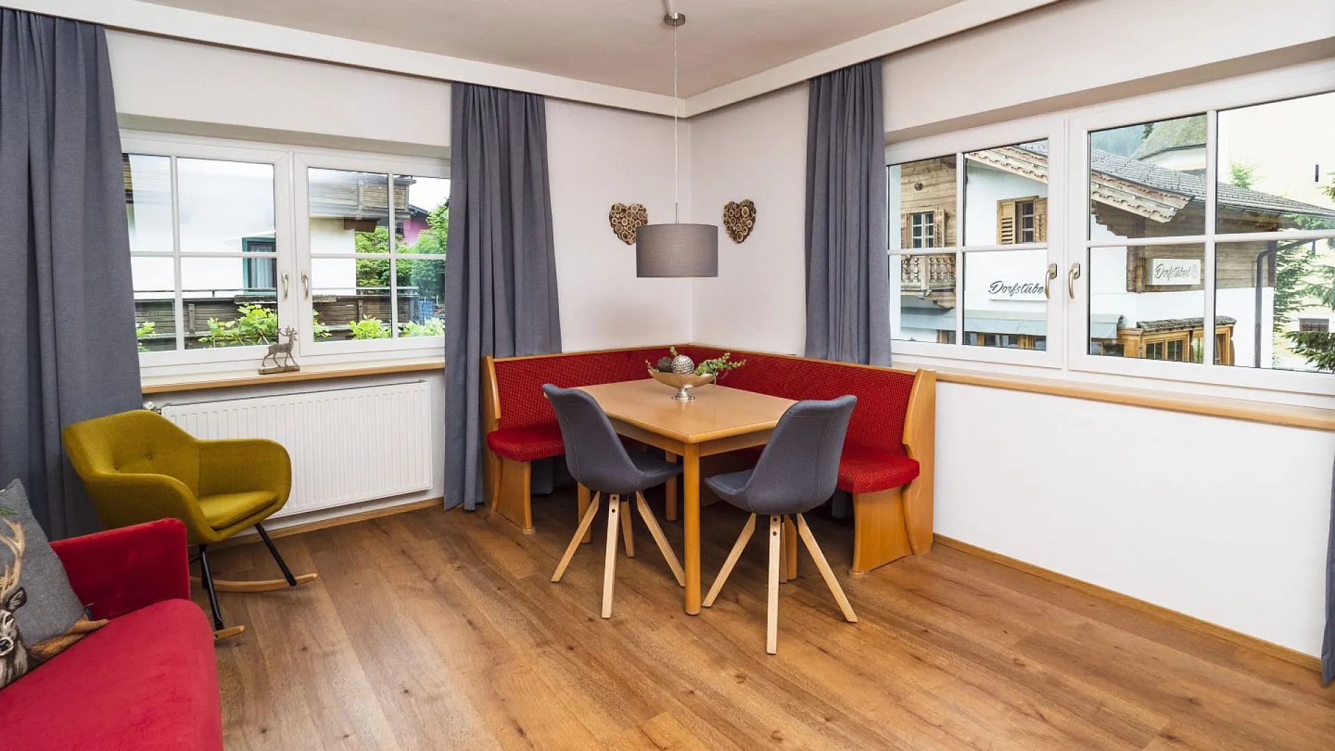 Heller Wohnbereich mit rotem Sofa und Esstisch