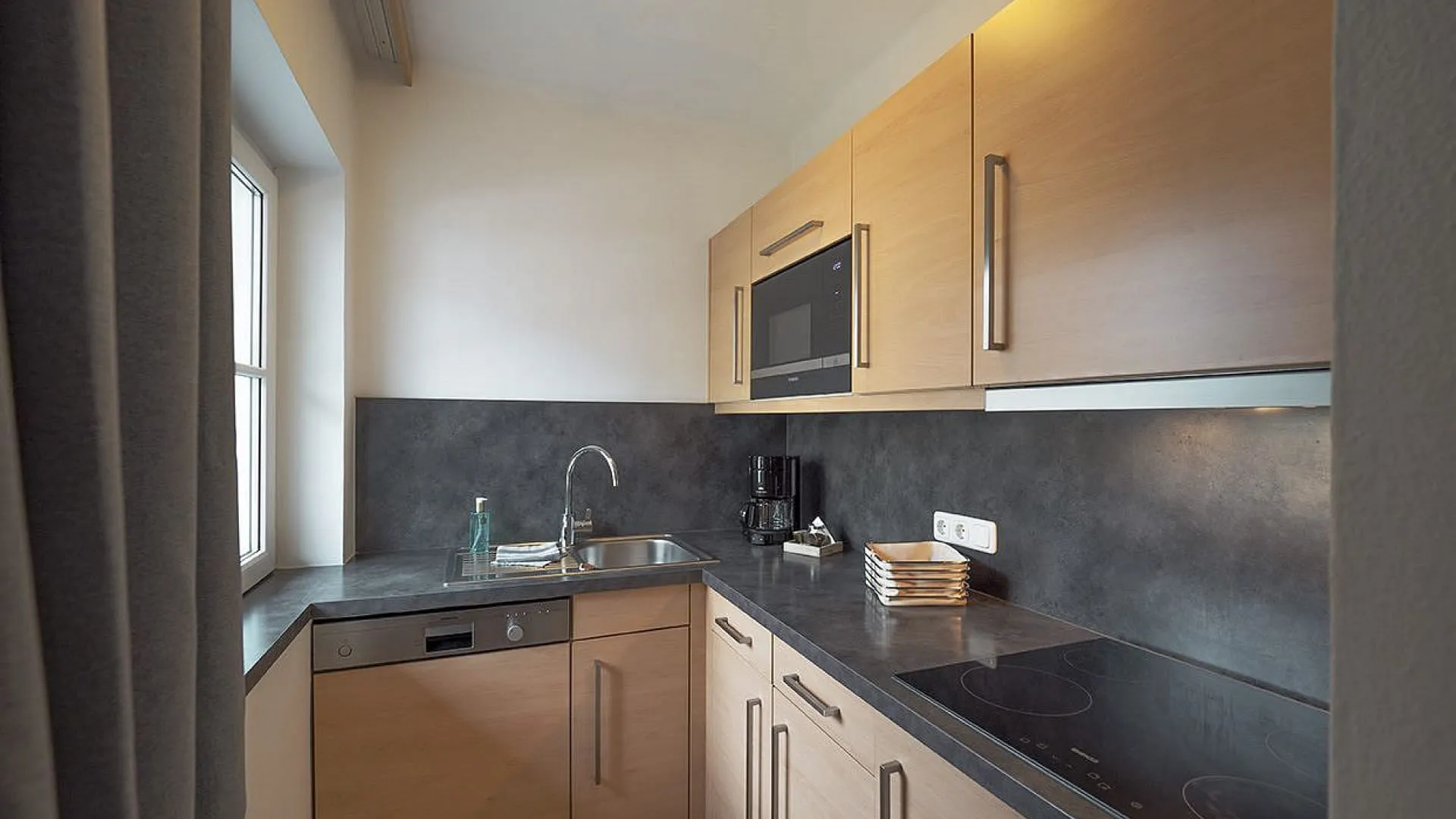 moderne Küche mit Holzmöbeln und Kochfeld