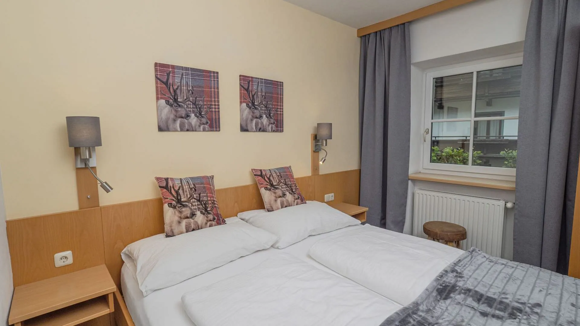 Helles Schlafzimmer mit zwei Bildern und grauen Vorhängen