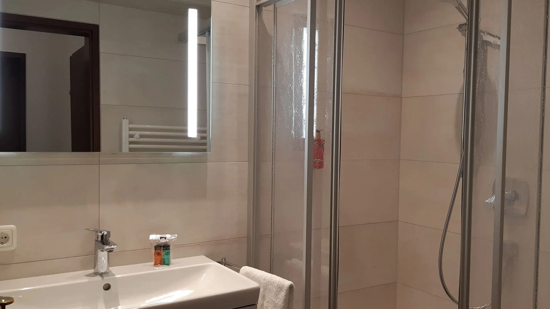 Helles Badezimmer mit Dusche und Spiegel